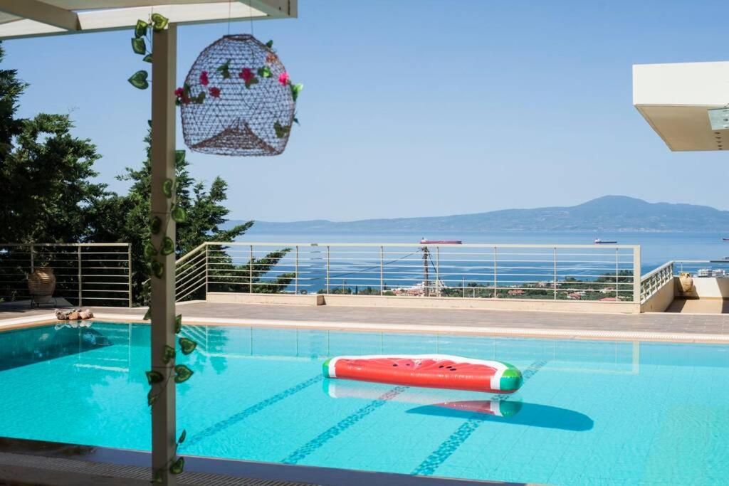 a swimming pool with a red raft in the water at Modern Luxury Villa with Pool, just 5min to sea in Kalamata