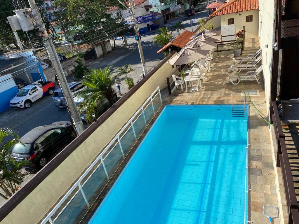 einen Blick über einen blauen Pool auf einem Gebäude in der Unterkunft Casa temporada Cabo Frio in Cabo Frio