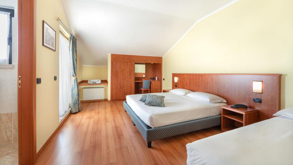 Postel nebo postele na pokoji v ubytování Hotel Postumia