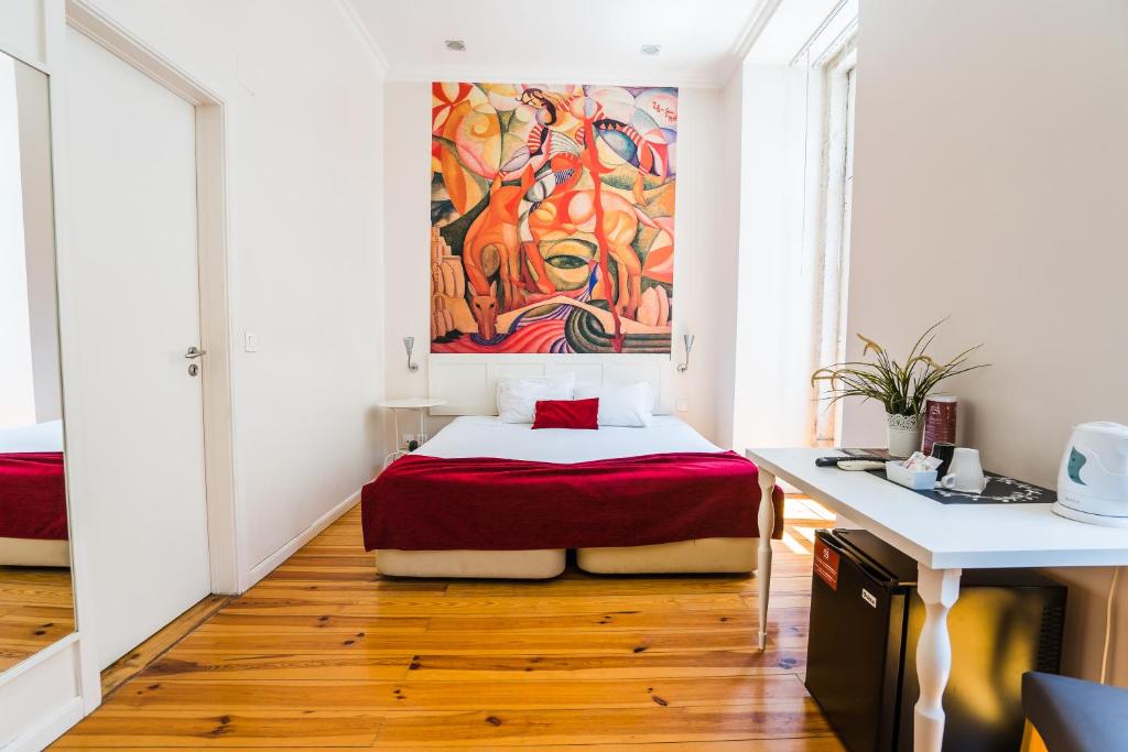 里斯本的住宿－里斯本阿森納套房酒店，卧室配有一张床,墙上挂有绘画作品