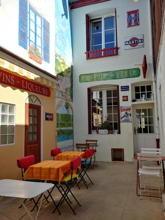 ein Restaurant mit Tischen und Stühlen vor einem Gebäude in der Unterkunft Doubs Séjour - Chambres et petits déjeuners in Verdun-sur-le-Doubs