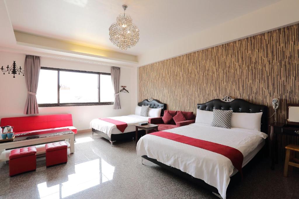 a hotel room with two beds and a couch at Redbean Guesthouse in Wujie