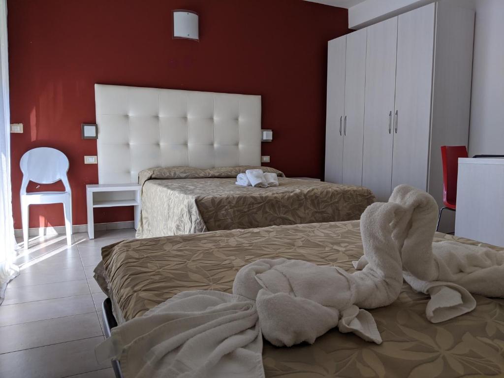 een hotelkamer met 2 bedden en een handdoek op het bed bij Residence Fiorita in Cesenatico