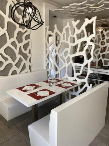 une salle à manger avec une table blanche et un mur dans l'établissement Casino Circus d'Allevard, à Allevard