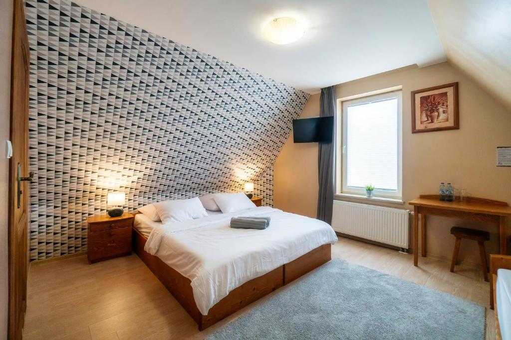 a bedroom with a bed and a brick wall at Pokoje gościnne Szy & Mon in Koniówka