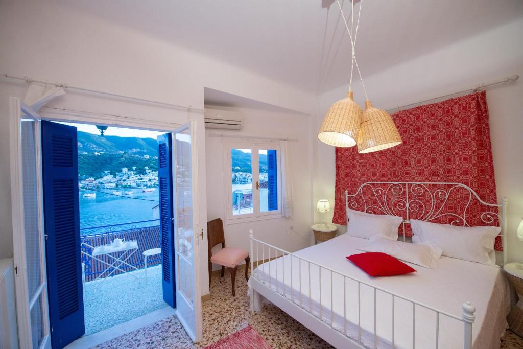 een slaapkamer met een wit bed en een rode muur bij Poros Home in Poros