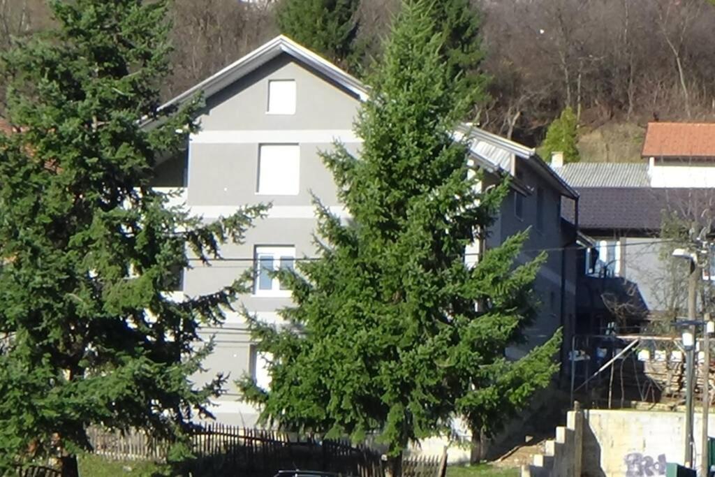 una casa blanca con árboles delante de ella en Vila E-N, en Sarajevo