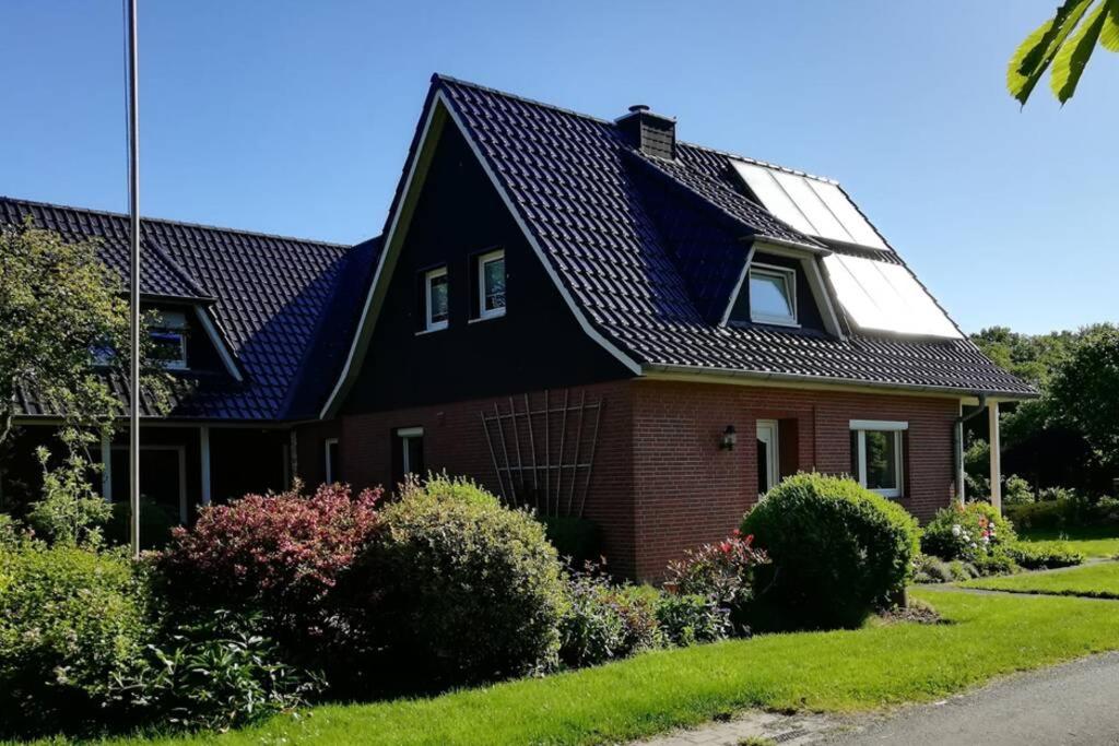 a brown house with a black roof at Ferienhaus im Grünen in Brunshausen