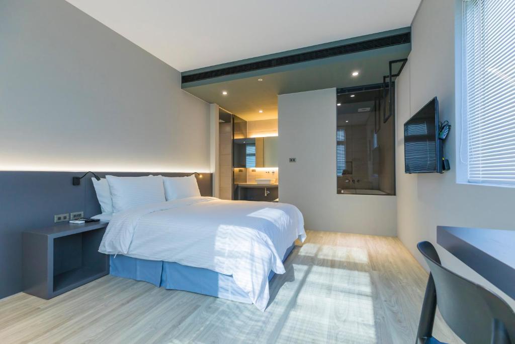 馬公市的住宿－好思包棟民宿，卧室配有一张白色大床和电视。
