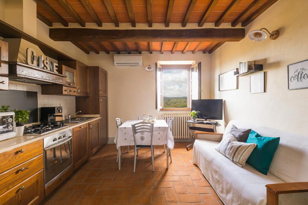Casa Franci في Contignano: مطبخ وغرفة معيشة مع أريكة وطاولة