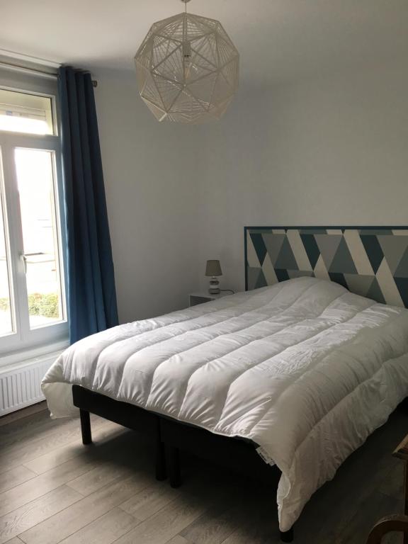 a bedroom with a bed and a large window at La Tanatte de wimereux sur la côte d opale in Wimereux