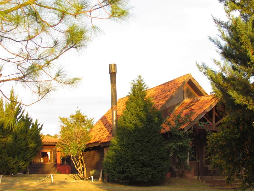 a log house with trees in front of it at Pousada La Vivienda in Santana do Livramento