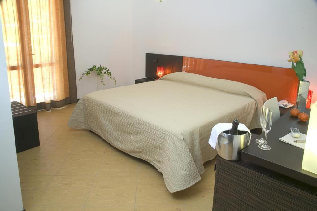 a bedroom with a large bed and a desk with at Castellammare Smart Rooms in Castellammare del Golfo