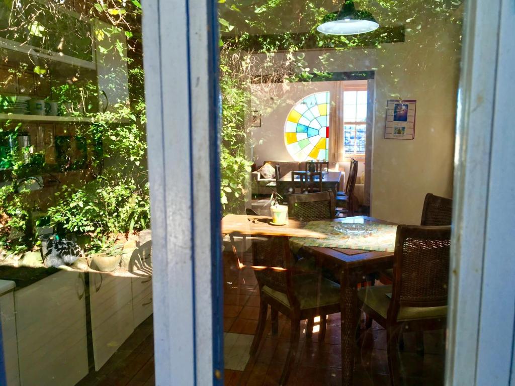 uma sala de jantar com uma mesa e cadeiras e uma janela em Residência Acolhedora em Porto Alegre
