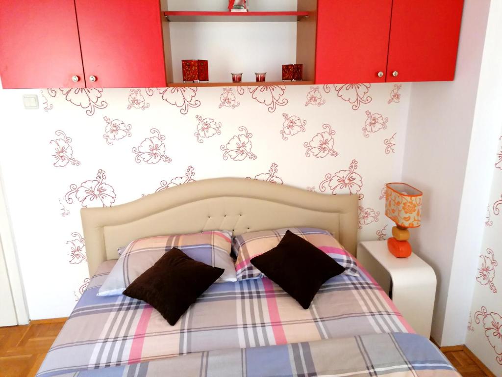 a bedroom with a bed with red cabinets at Apartman Nena in Nova Varoš