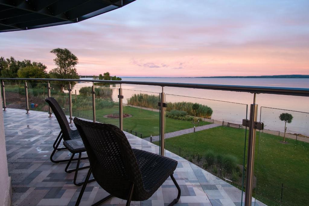 a balcony with chairs and a view of the water at Apartman Balaton in Keszthely