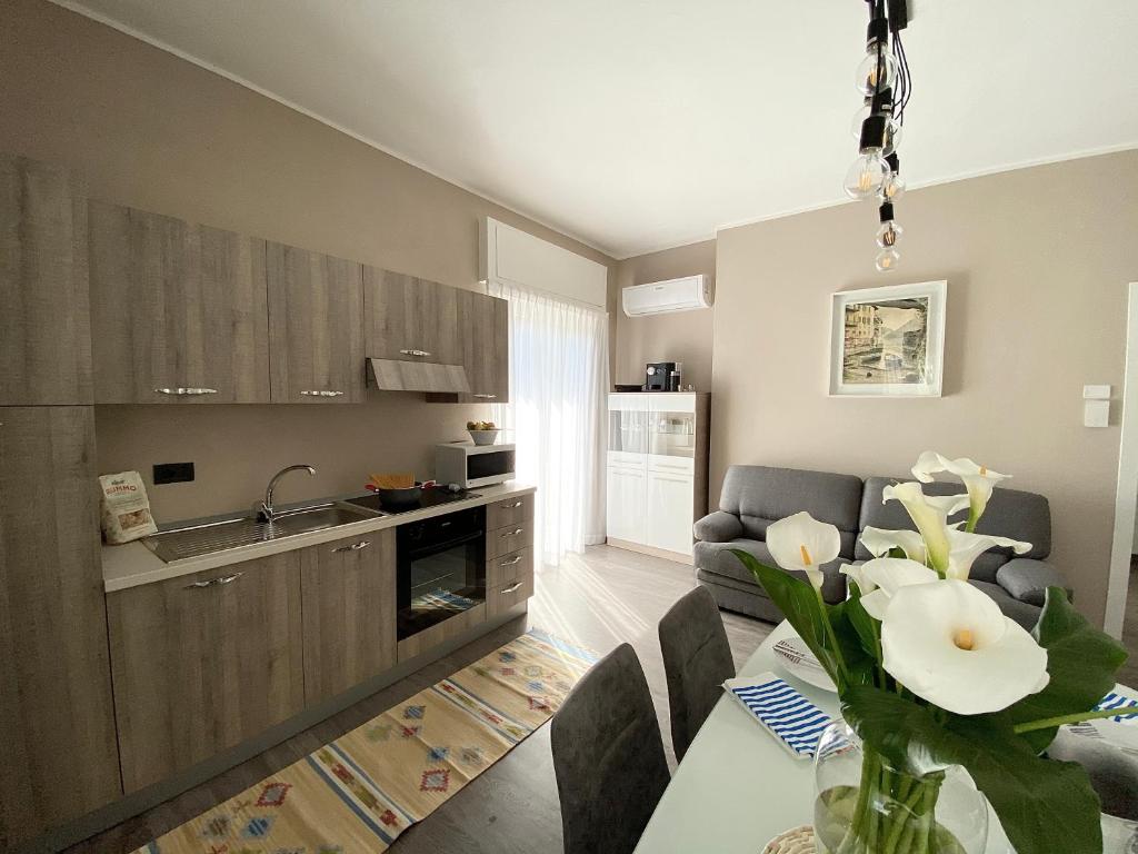 a kitchen and living room with a table and a couch at Appartamento Renzo, Dongo, Lago di Como in Dongo
