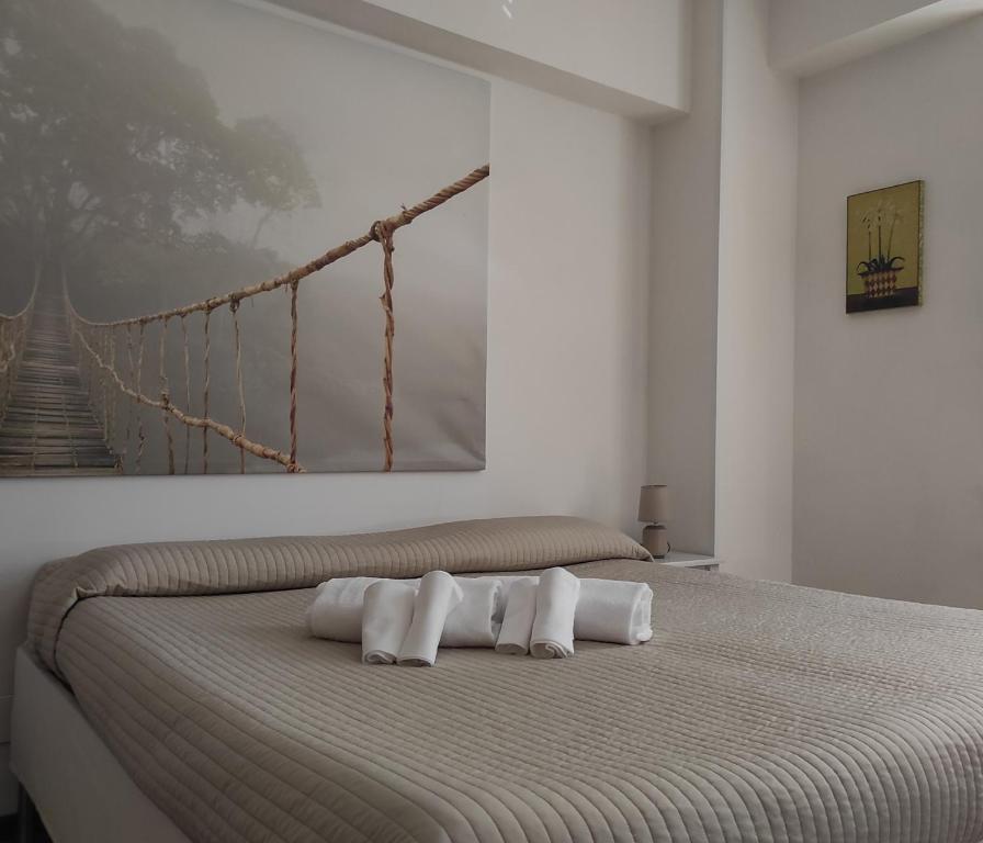 1 dormitorio con 1 cama con 3 almohadas en MONOLOCALI DA VINCI, en Falconara Marittima