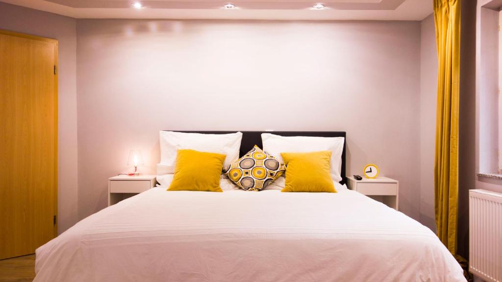 a bedroom with a large white bed with yellow pillows at Your Studio in Fichtenau