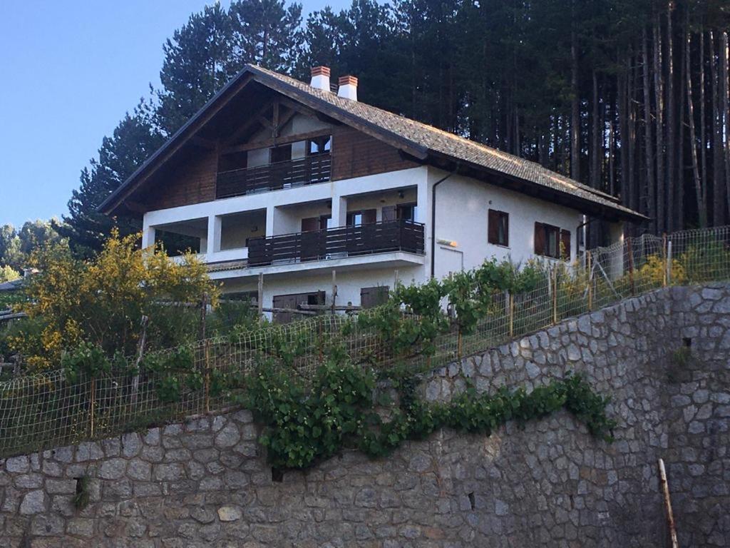 a house on top of a stone wall at Tra il bosco e il lago in Lorica