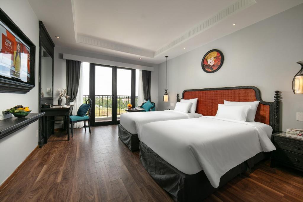 Postel nebo postele na pokoji v ubytování Shining Riverside Hoi An Boutique & Spa