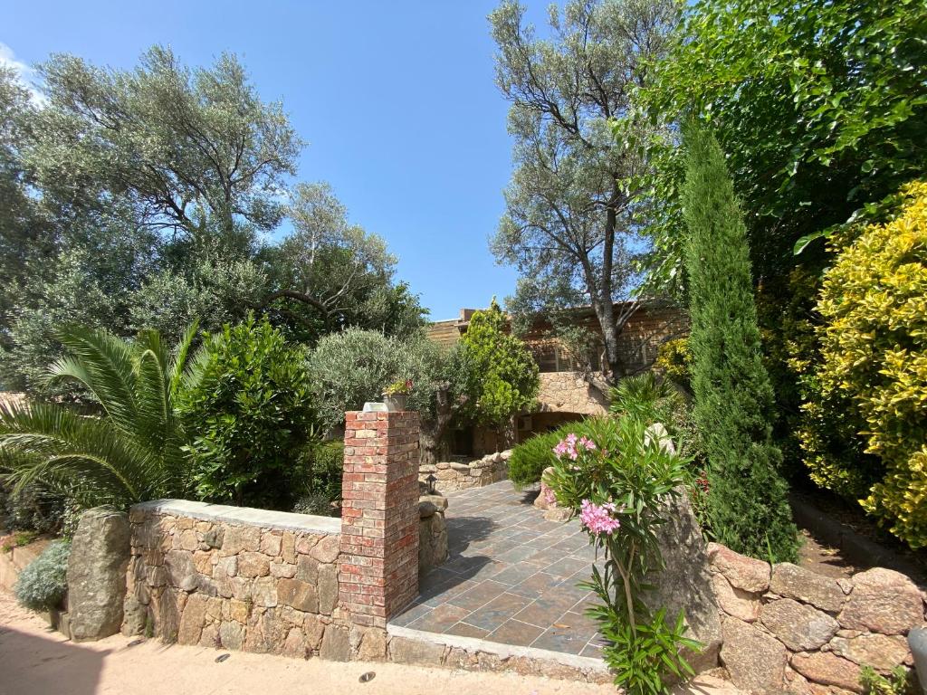 un jardin avec une passerelle en briques et un mur en pierre dans l'établissement Hotel gite d'etape San Pasquale, à Conca