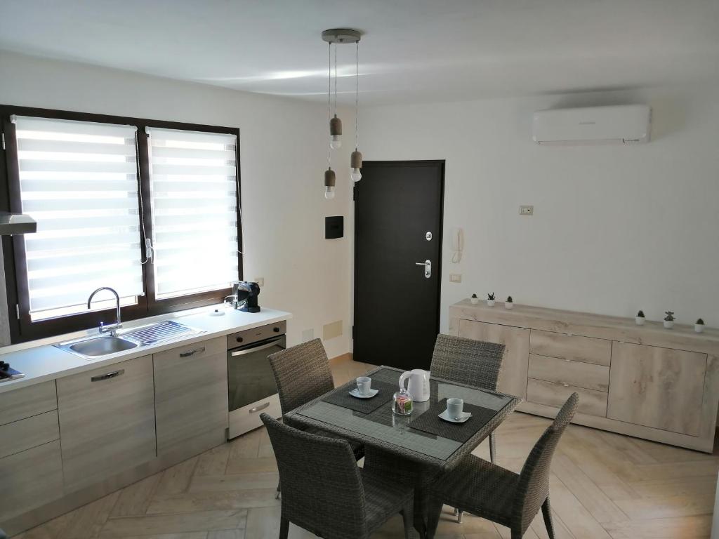 eine Küche mit einem Tisch und Stühlen im Zimmer in der Unterkunft Appartamento Monte Granatico 01 in SantʼAntìoco