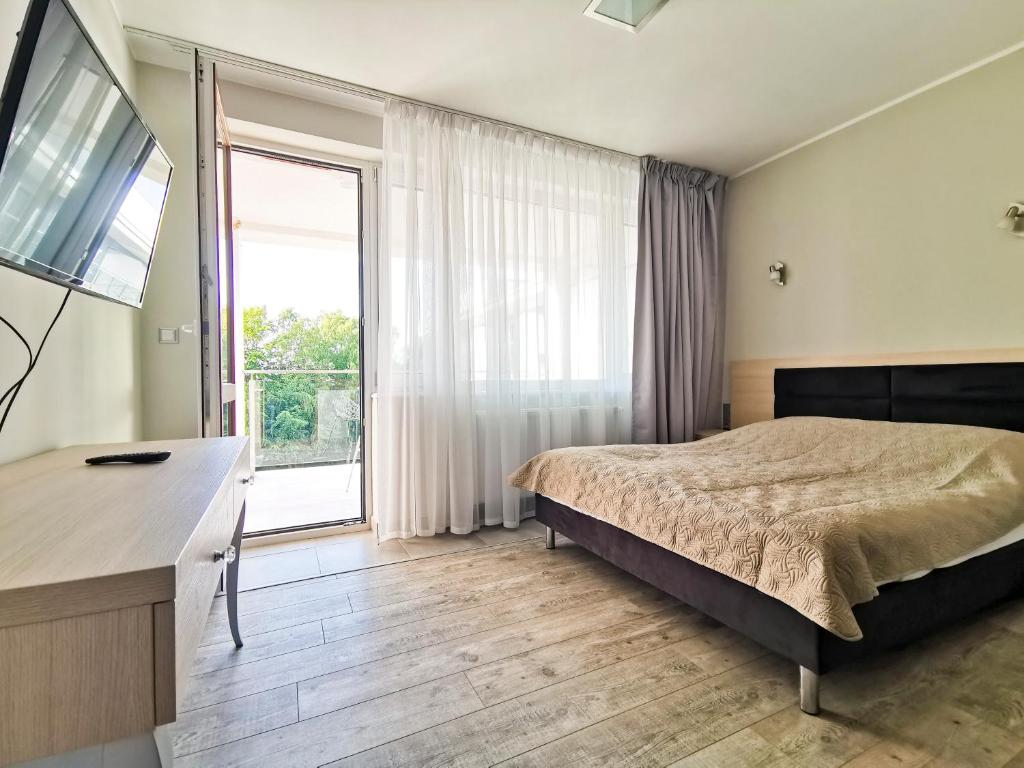 1 dormitorio con cama y ventana grande en Apartament Dominikana, en Sianożęty
