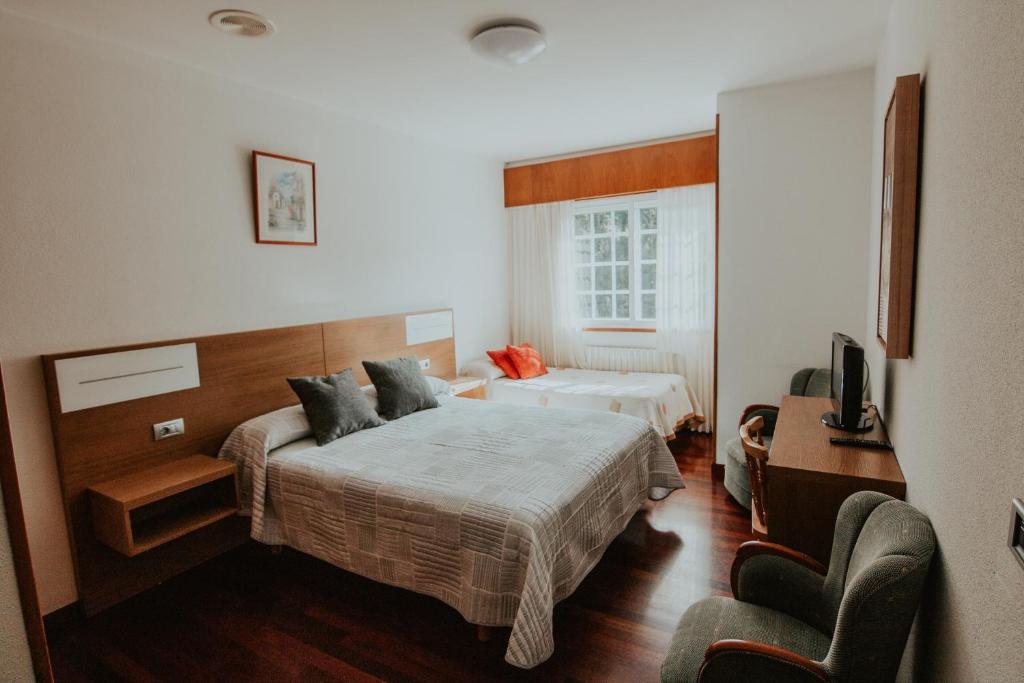 pokój hotelowy z dwoma łóżkami i telewizorem w obiekcie Hotel A Veiga w mieście Samos