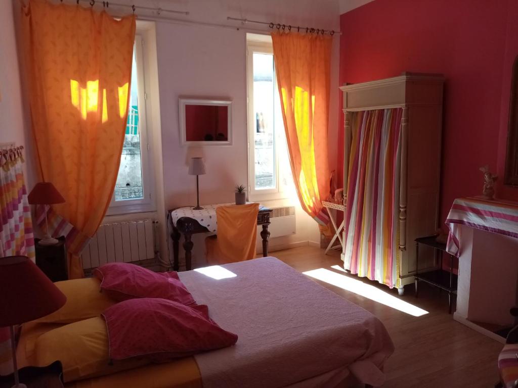 シジャンにあるLa Maison Bleue de Sigeanのベッドルーム1室(ベッド1台、窓2つ、テーブル付)