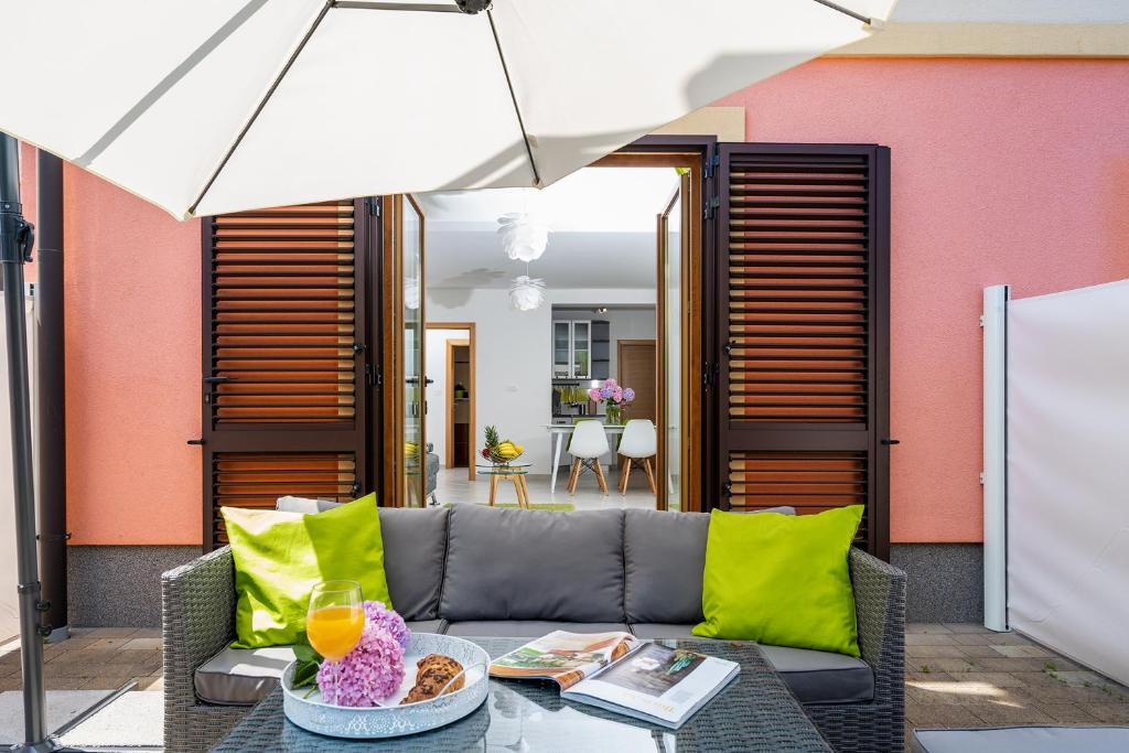 a patio with a couch and an umbrella at Downtown Apartments Dorian and Nadia in Opatija