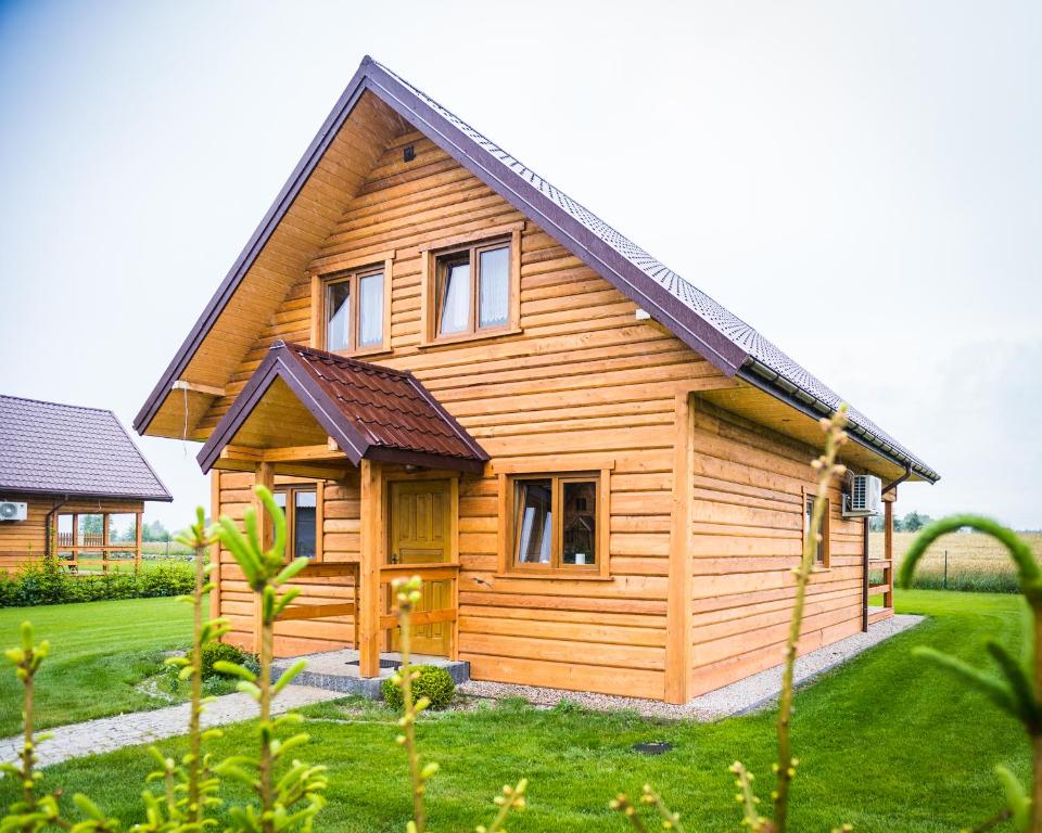 una pequeña casa de madera en un campo de hierba en Kraina Dauby, en Wielowieś