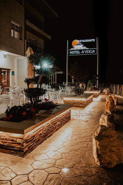 patio w hotelu w nocy ze stołami i krzesłami w obiekcie Hotel A Veiga w mieście Samos