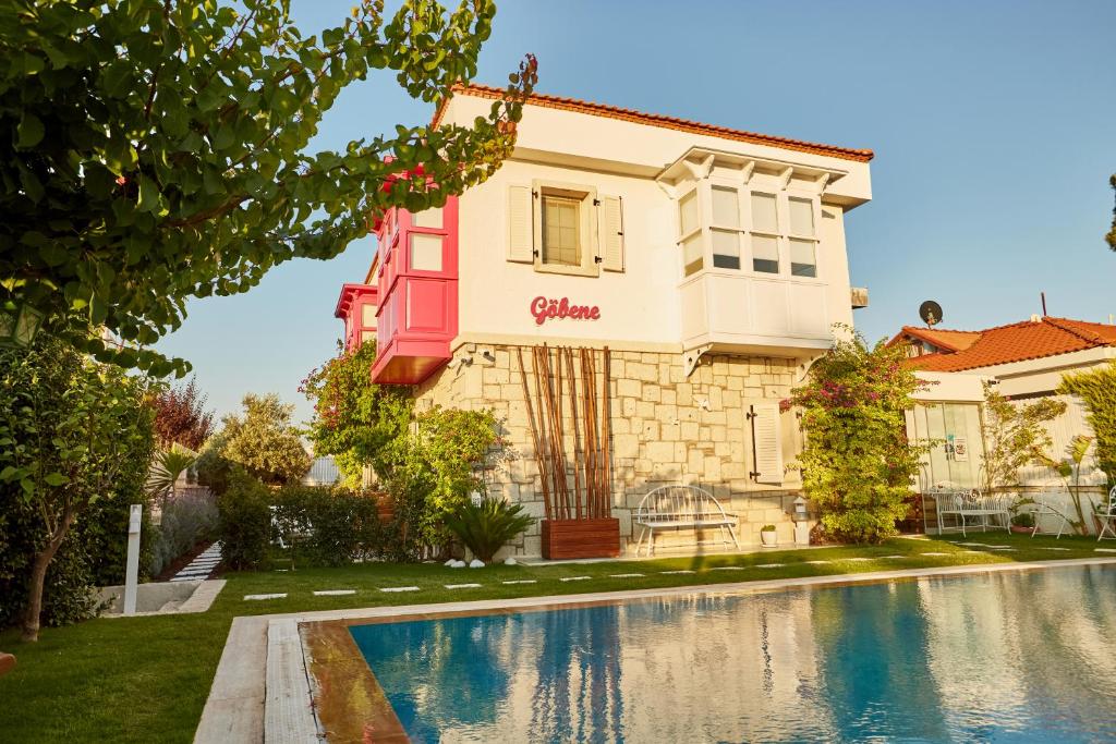 a villa with a swimming pool in front of a house at Gobene Alacati in Alaçatı