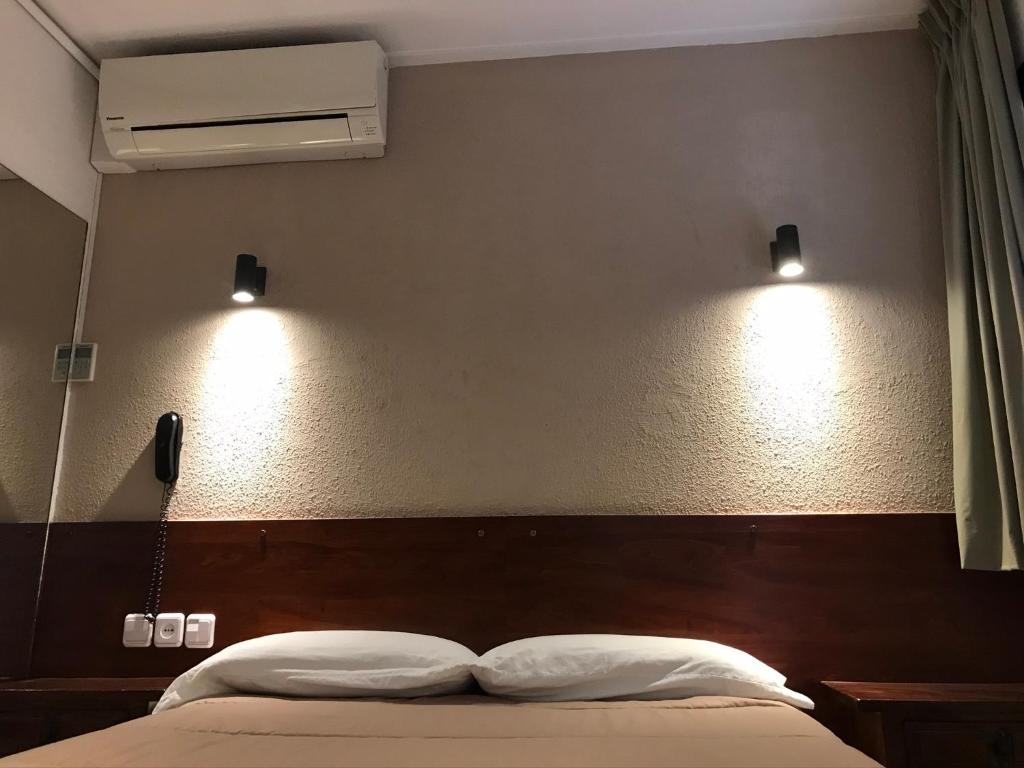 a bedroom with a bed with two lights on the wall at Hostal Radio Barcelona in Barcelona