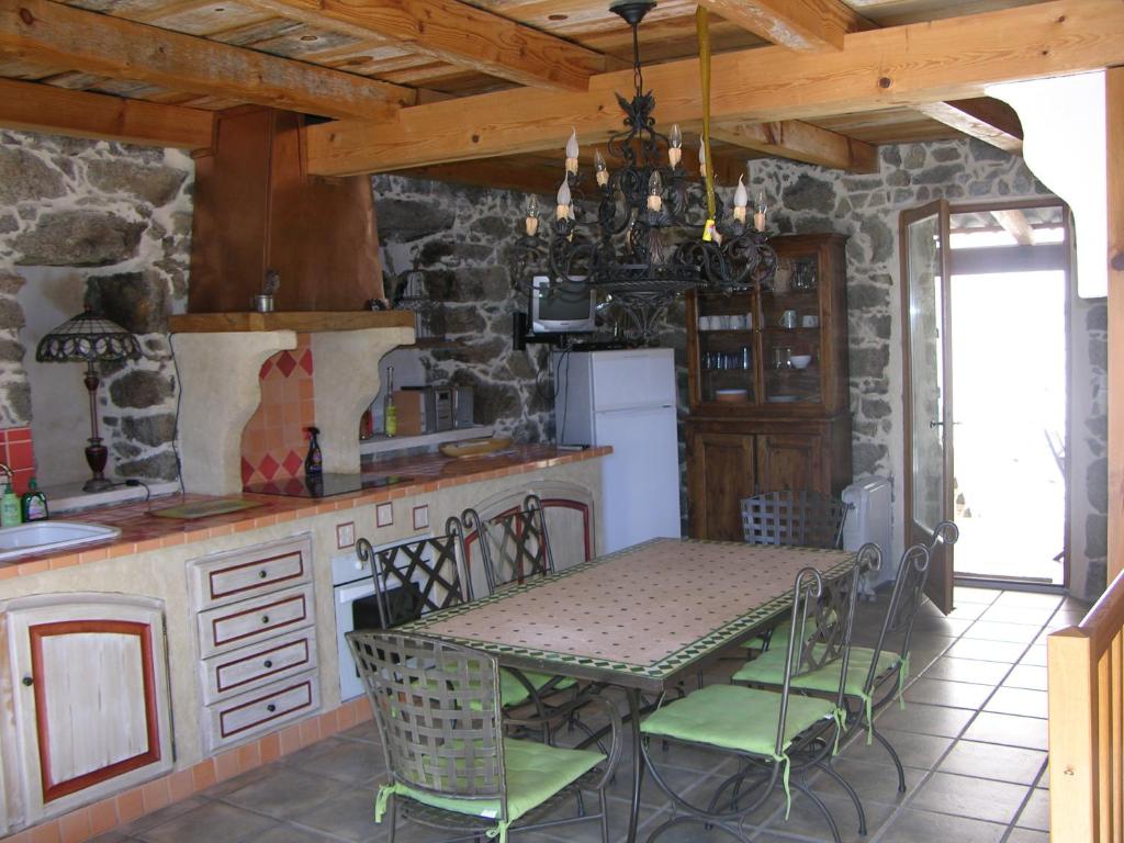a kitchen with a table and a stone wall at Maison Le Rêve in Evisa