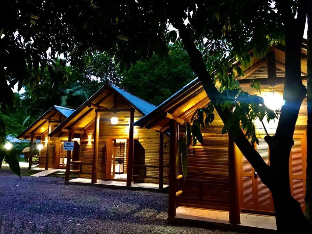 a row of wooden cabins in a forest at night at Chalés Itaimbezinho in Praia Grande