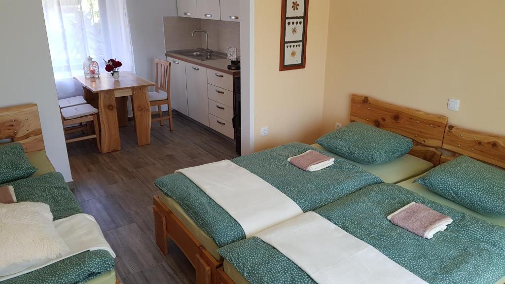 1 dormitorio con 2 camas y cocina con mesa en Seventh house, en Ilirska Bistrica