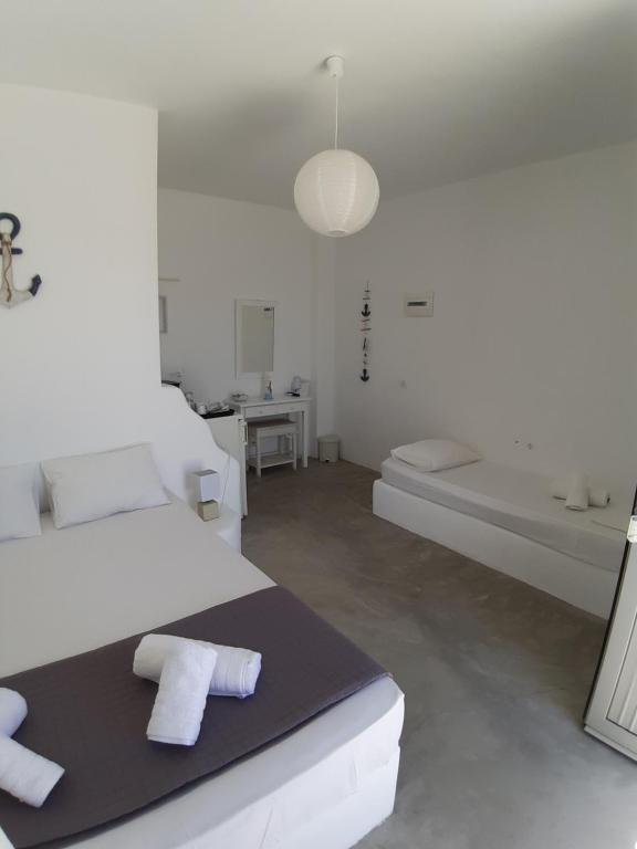 Habitación blanca con cama y bañera en Thea Serifos, en Livadakia
