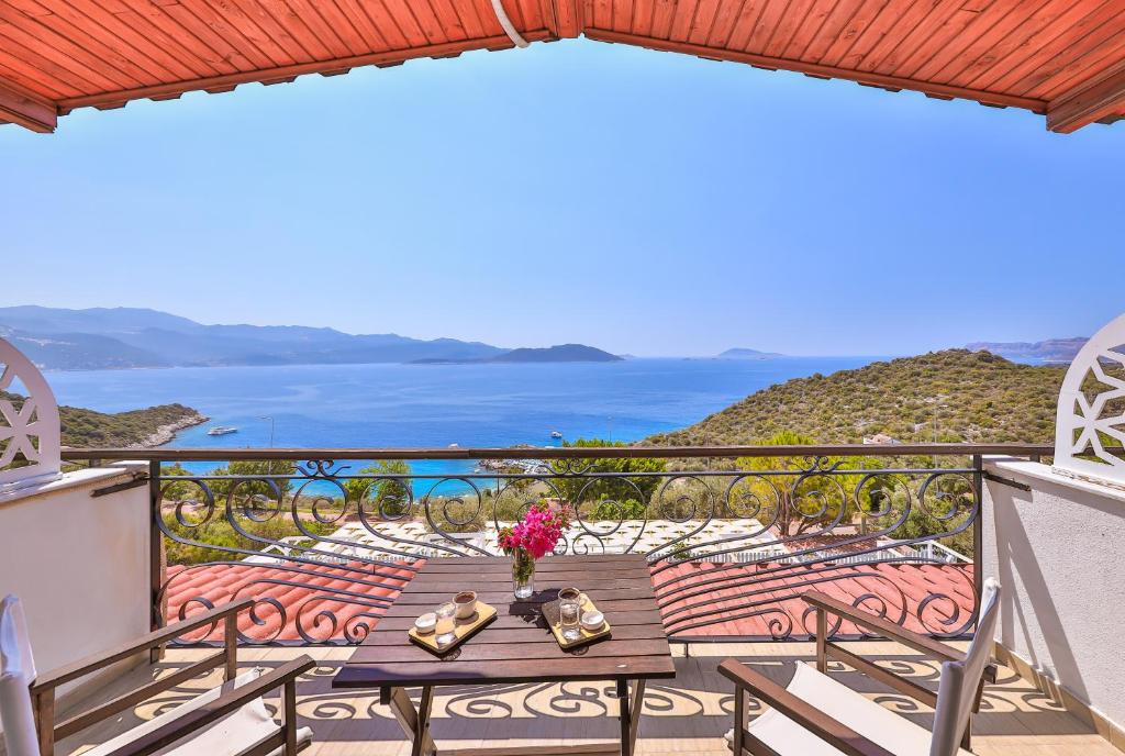 a balcony with a table and a view of the ocean at Hamarat Otel in Kaş