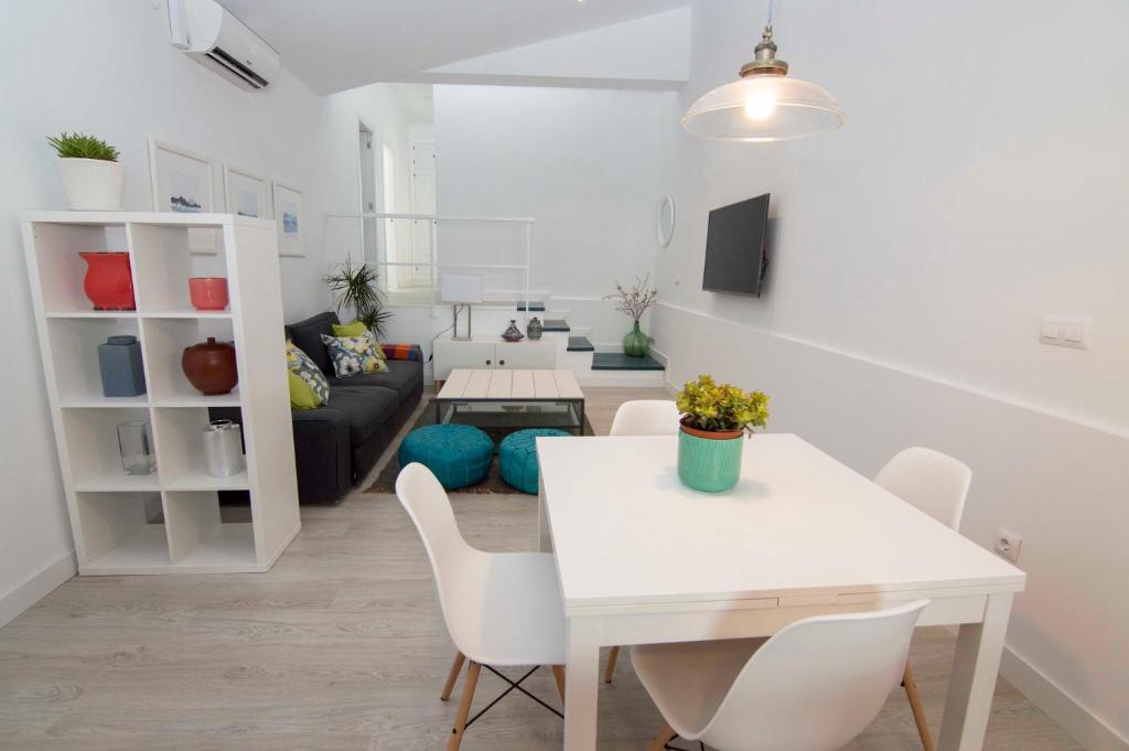 a living room with a white table and chairs at Casa Izaro in Sanlúcar de Barrameda