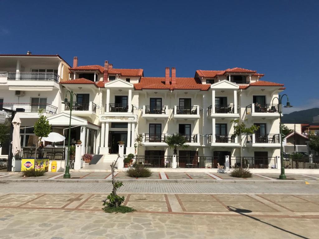 a large white building with a red roof at Makedos Sea View in Nea Vrasna