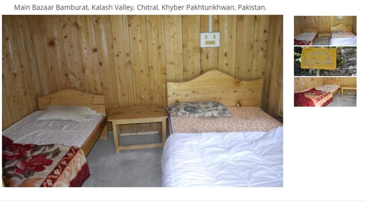 two beds in a room with wooden walls at Sikander Inn Chitral in Anīahgrām