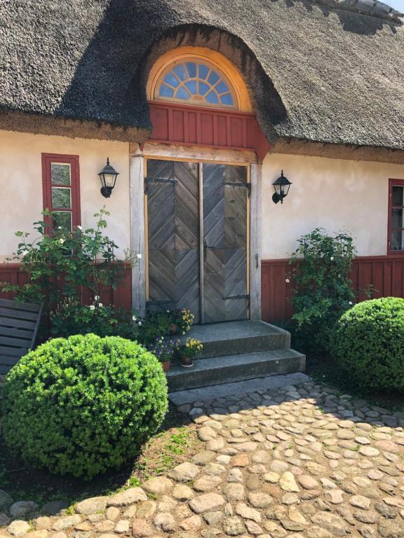 ein Haus mit einem Strohdach und einer Tür in der Unterkunft Vasatorps Matologi in Helsingborg