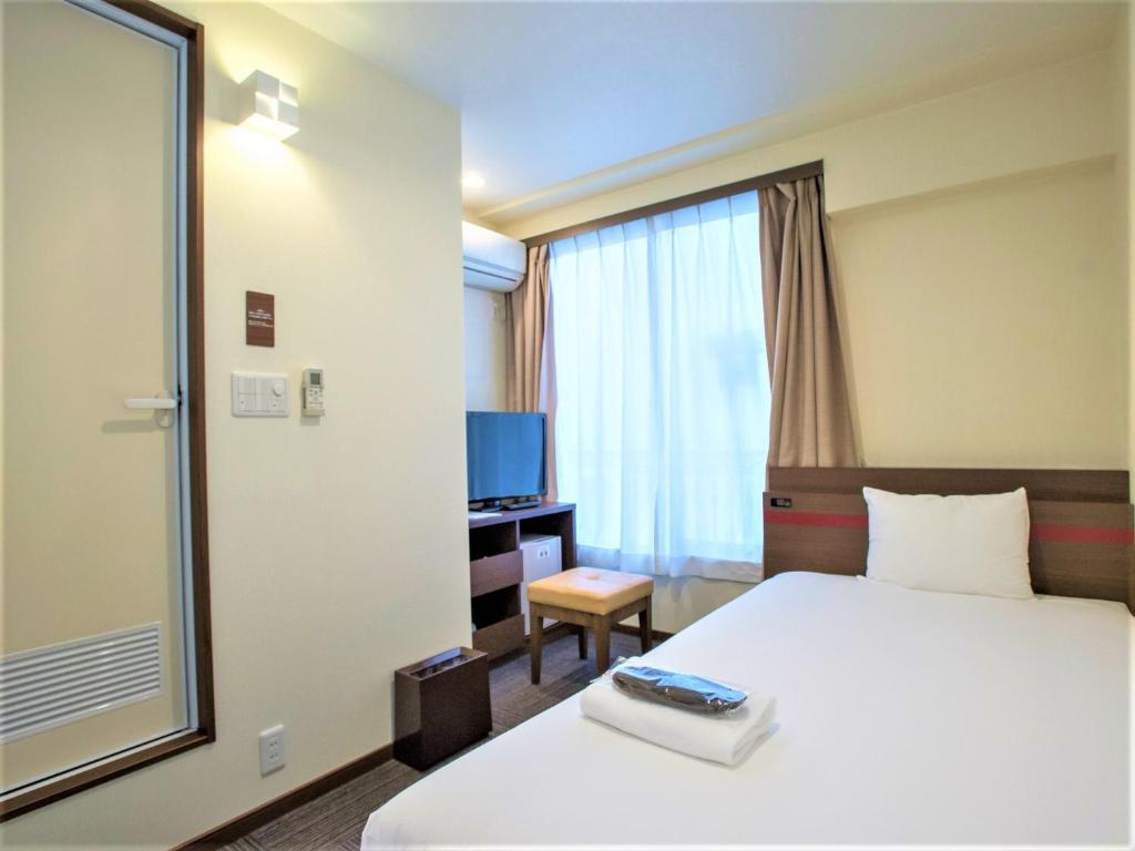 SHIN YOKOHAMA SK HOTEL - Smoking - Vacation STAY 86103 في يوكوهاما: غرفه فندقيه بسرير ونافذه