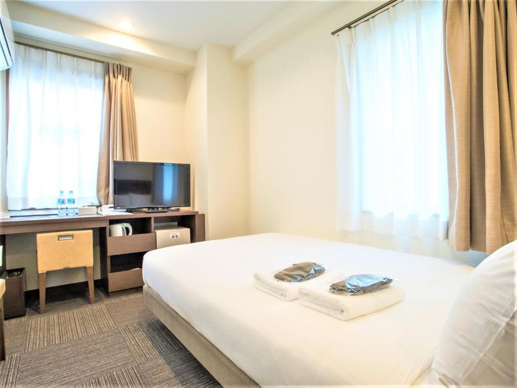 横浜市にあるSHIN YOKOHAMA SK HOTEL - Smoking - Vacation STAY 86108のベッド、デスク、テレビが備わるホテルルームです。