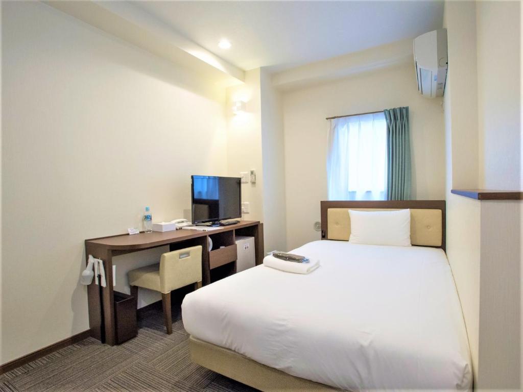 um quarto de hotel com uma cama e uma secretária com um computador em SHIN YOKOHAMA SK HOTEL - Non Smoking - Vacation STAY 86104 em Yokohama