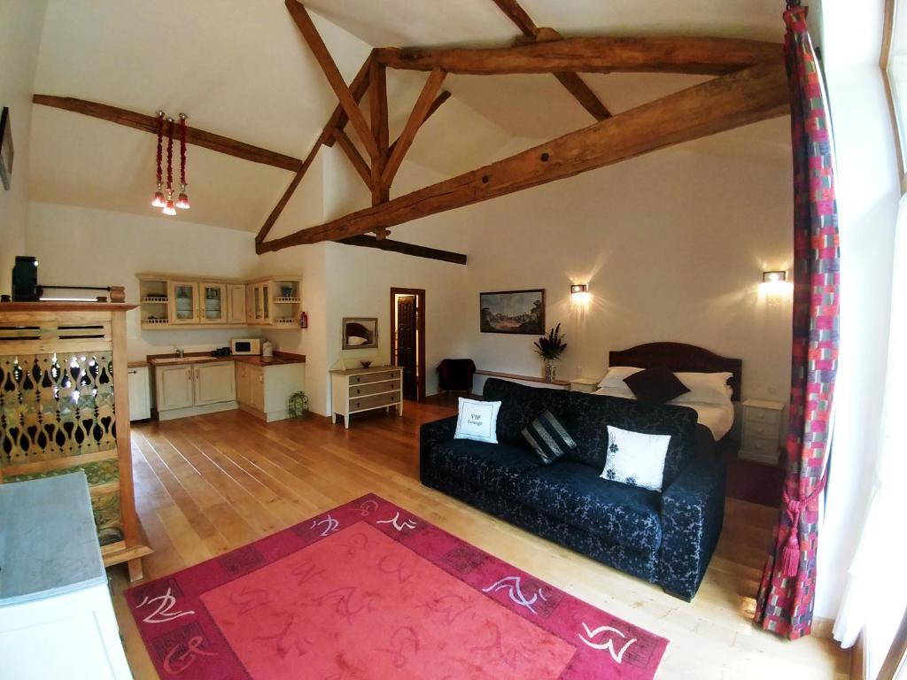 un salon avec un canapé noir et une cuisine dans l'établissement L`Atelier, à Saint-Martial-Viveyrol