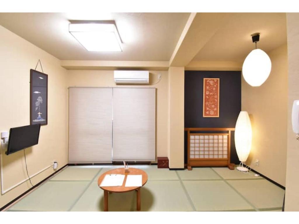 een kamer met een tafel en een tv. bij Guest House hanare - Vacation STAY 85819 in Osaka