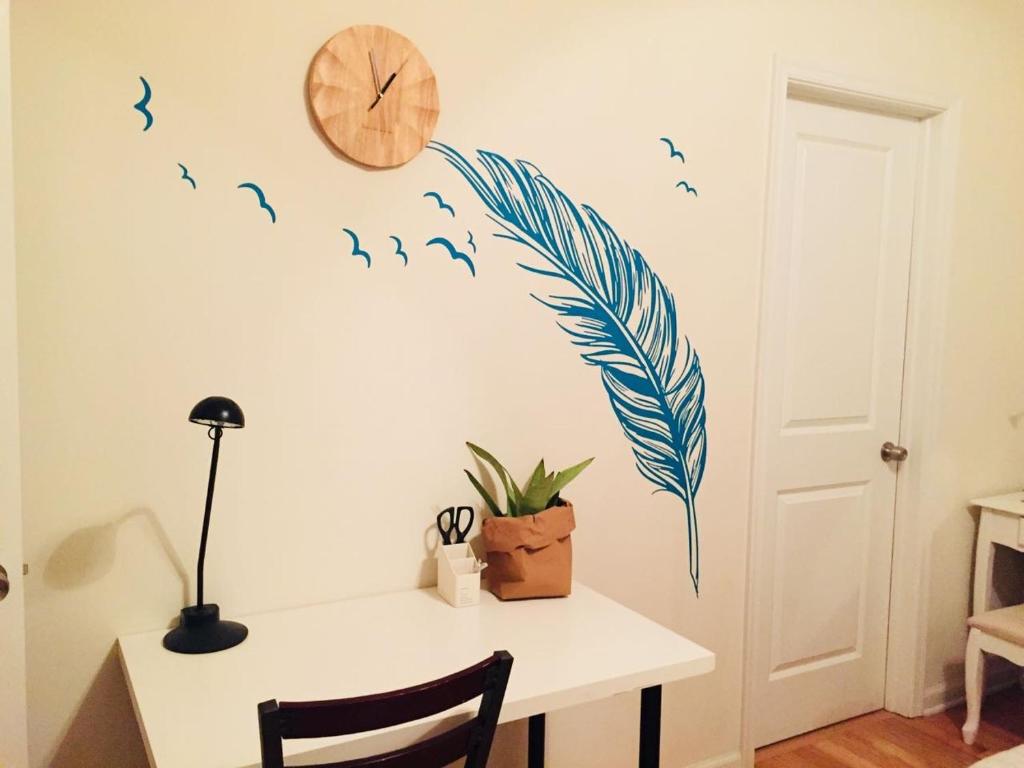 einen Schreibtisch mit Vogel-Design an einer Wand mit einer Uhr in der Unterkunft Cozy bedrooms at University City in Philadelphia in Philadelphia